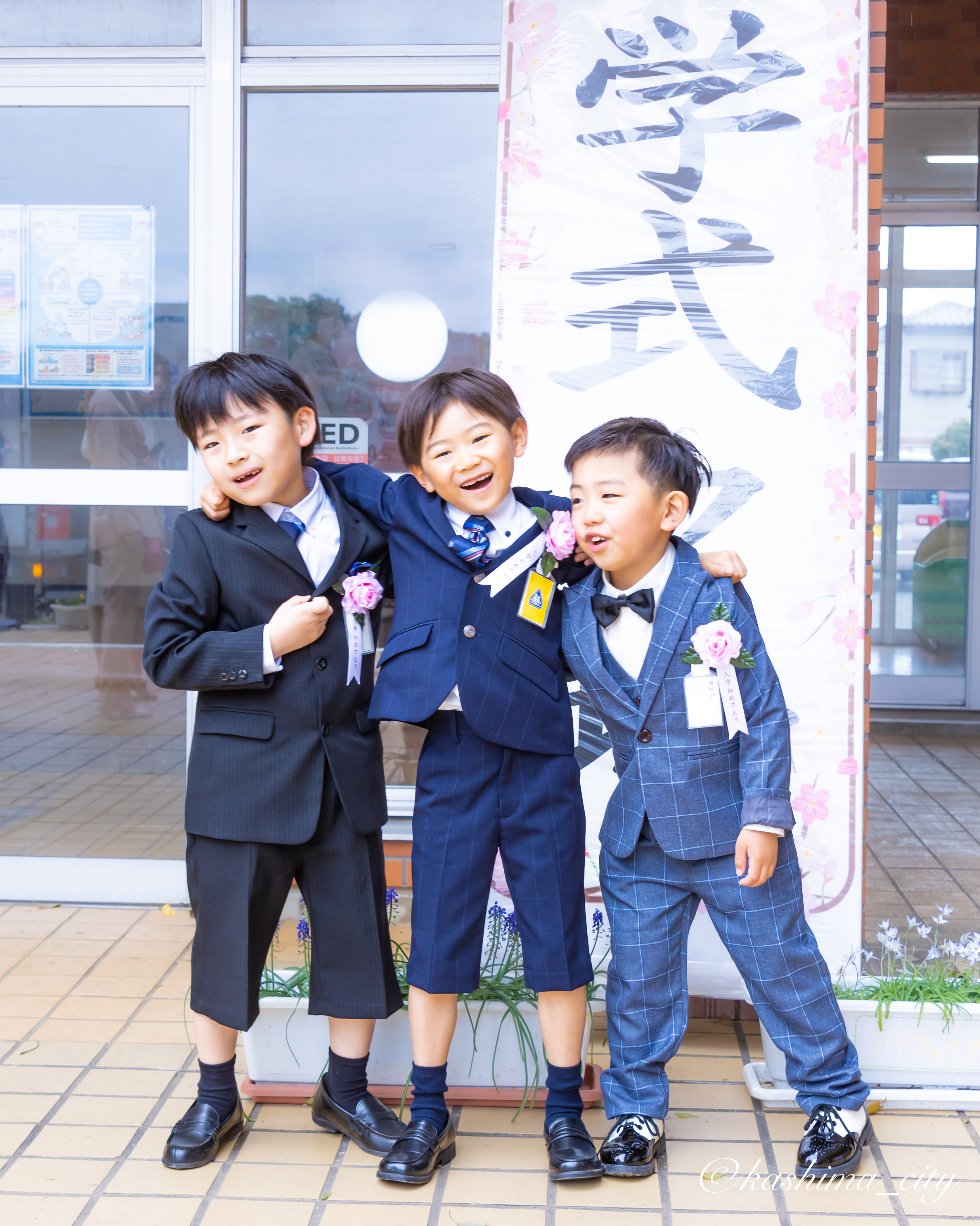 肩を組む男子児童三人