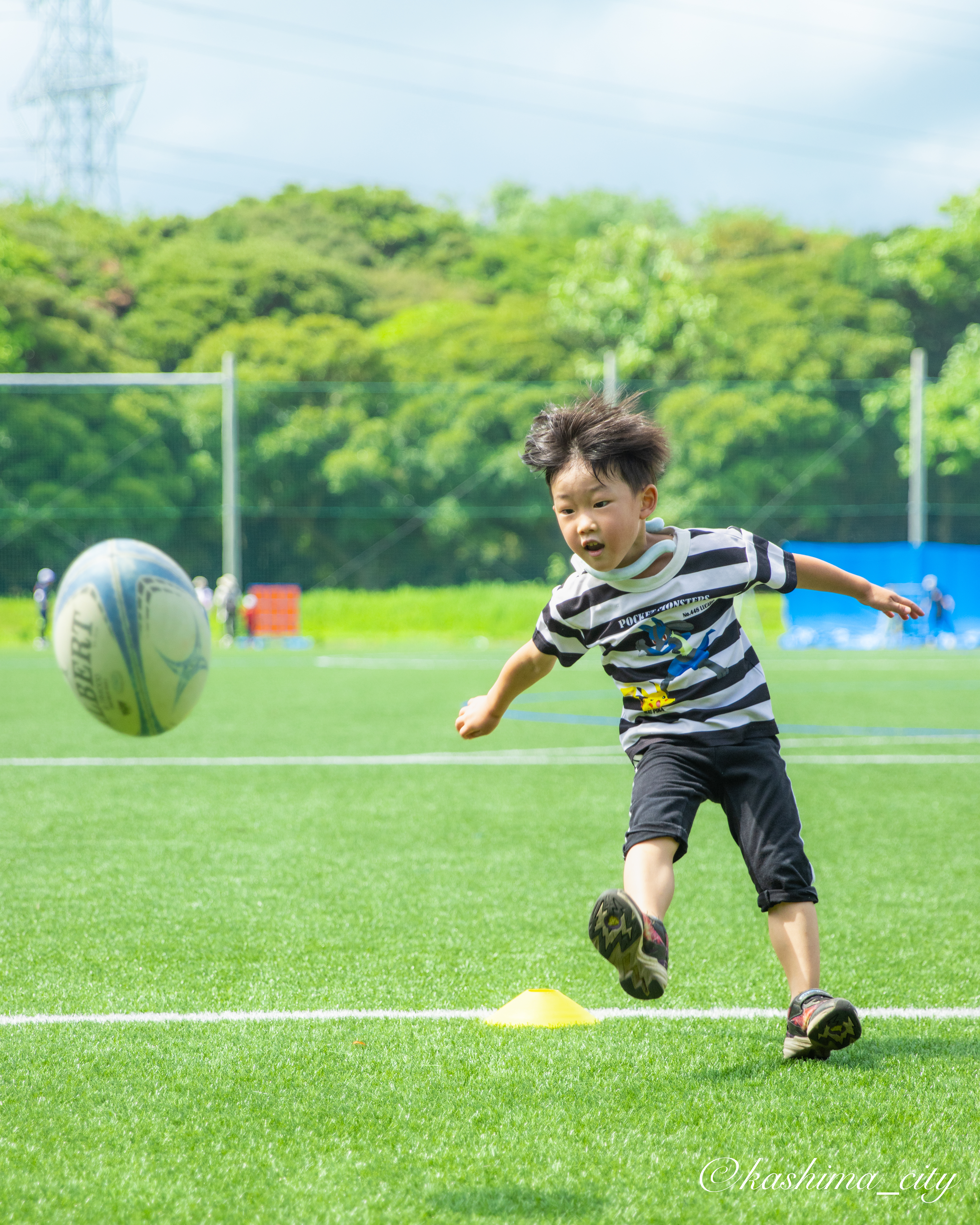 ラグビーボールをキックする男の子