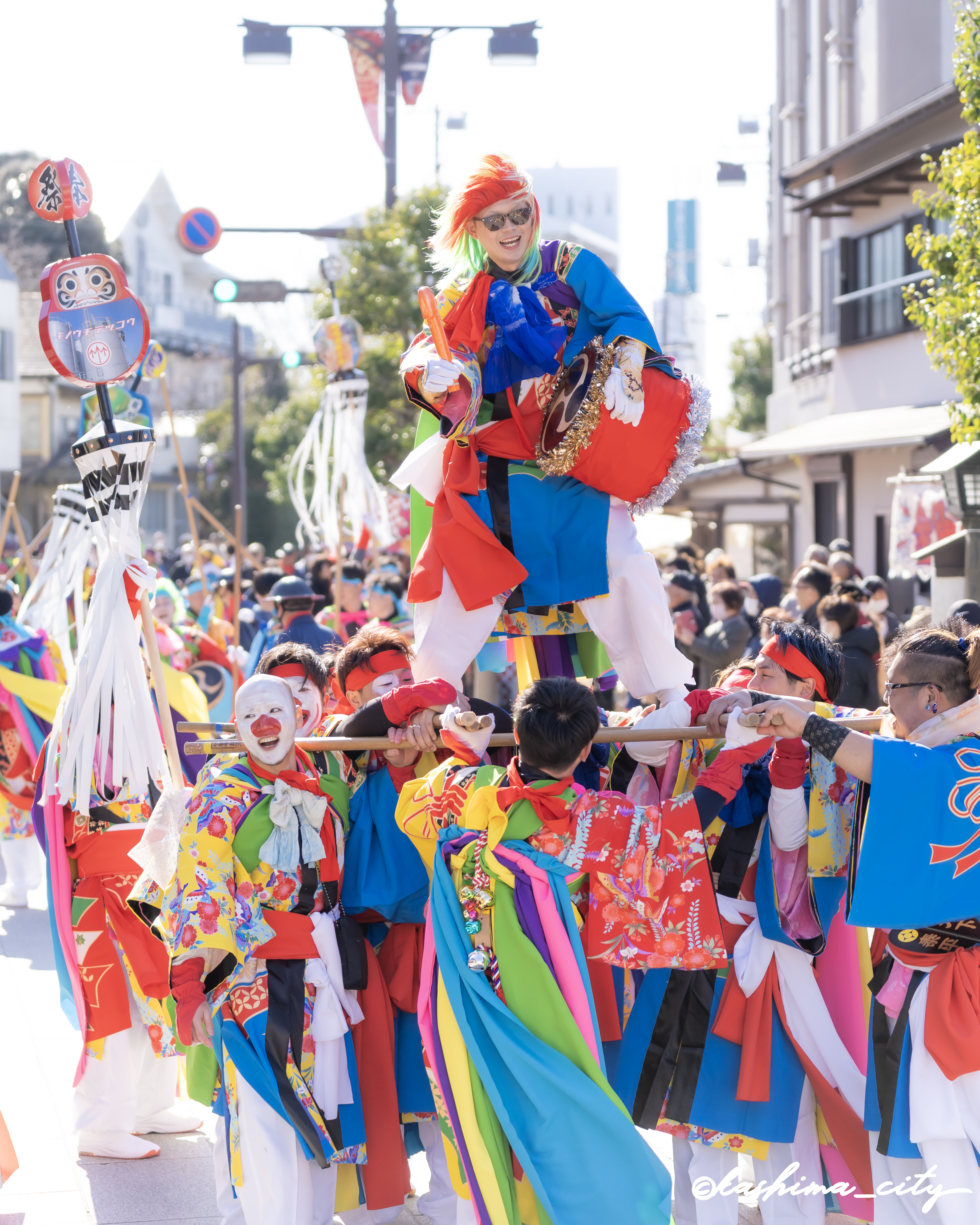 樫棒に乗り太鼓をたたく男性