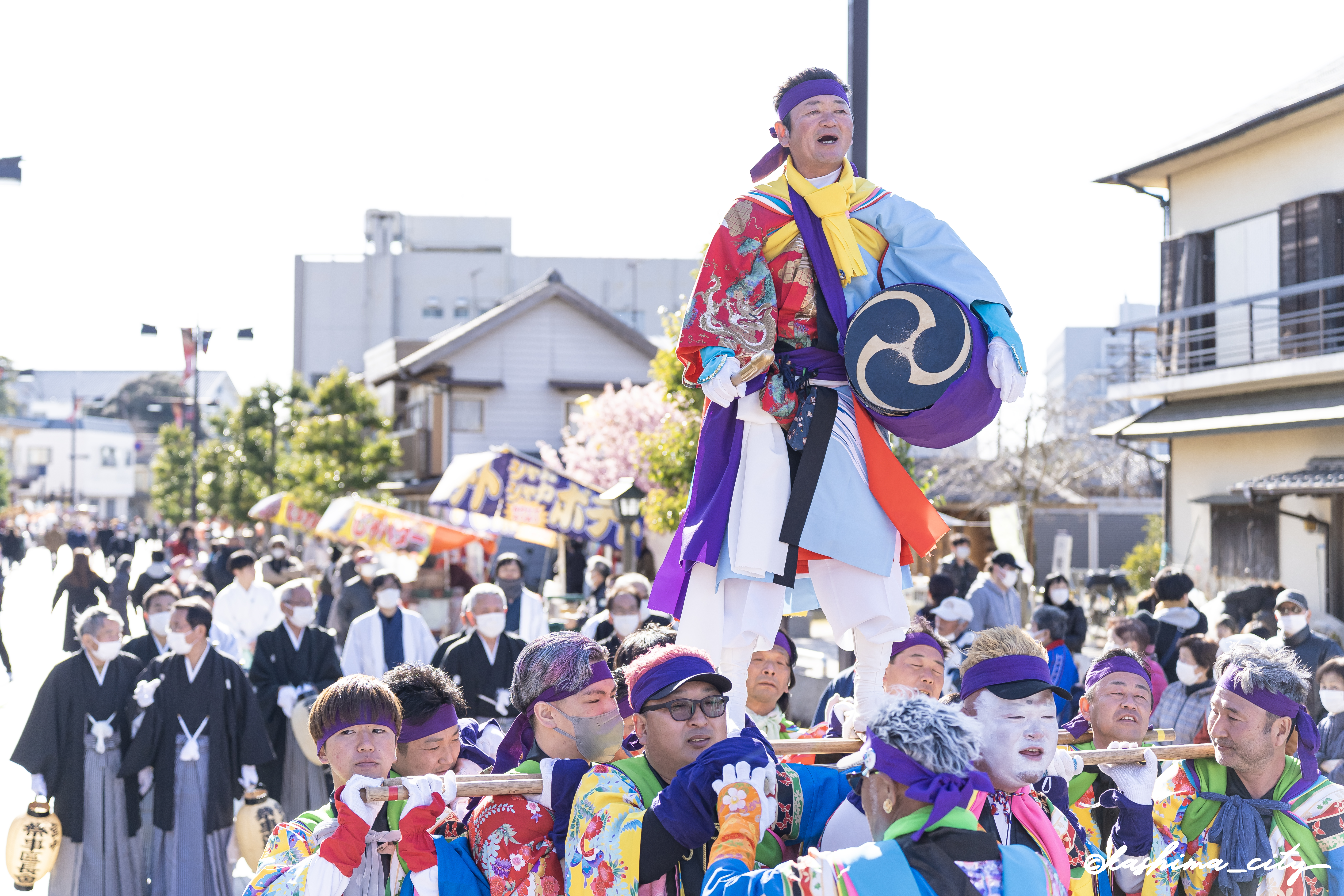 樫棒の上で太鼓を叩く男性