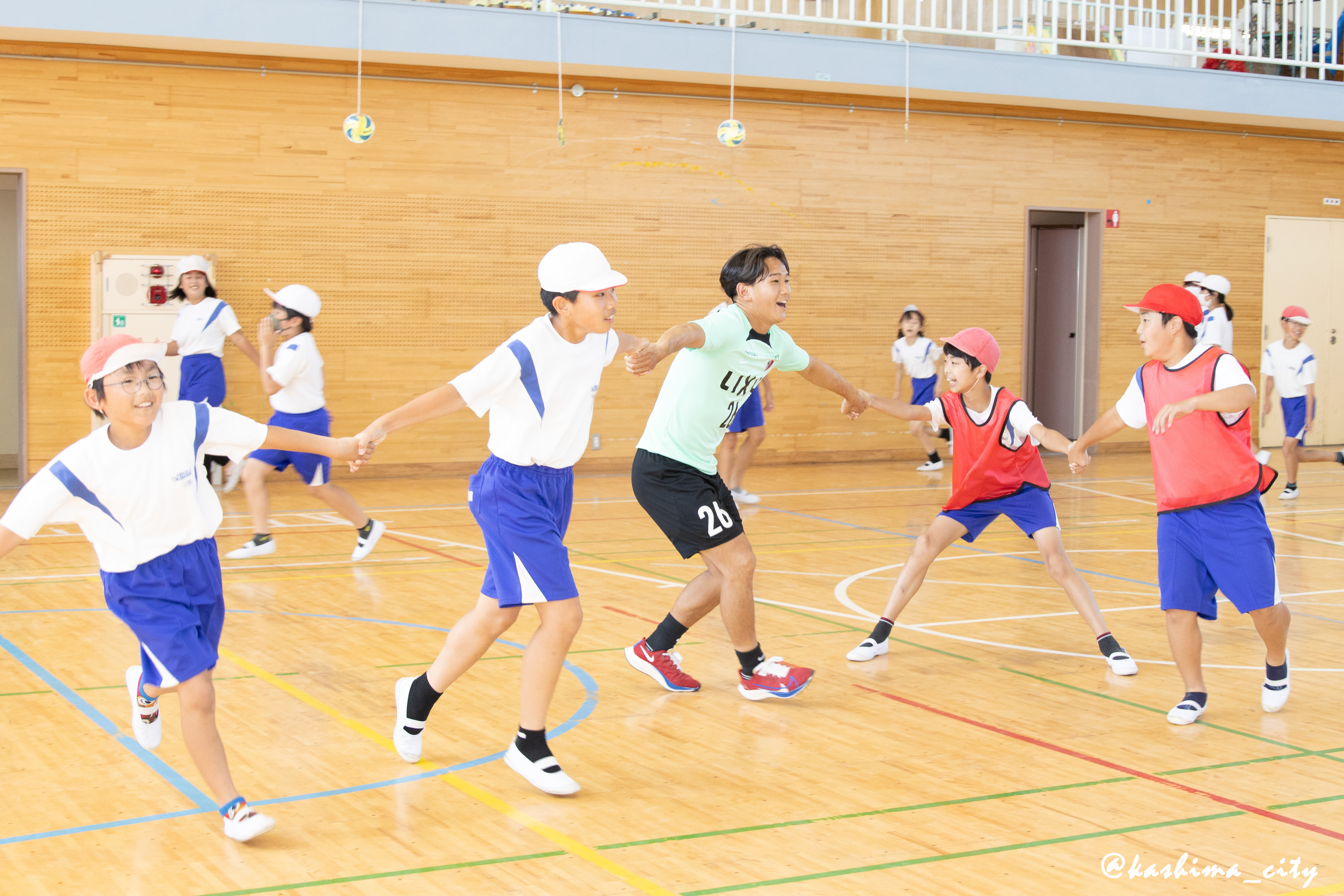 子どもたちと手をつなぐ須藤選手