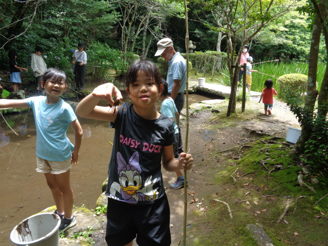 釣ったザリガニを掴んでる子ども