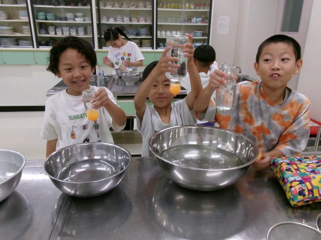 水の表面張力を実験する子どもたち