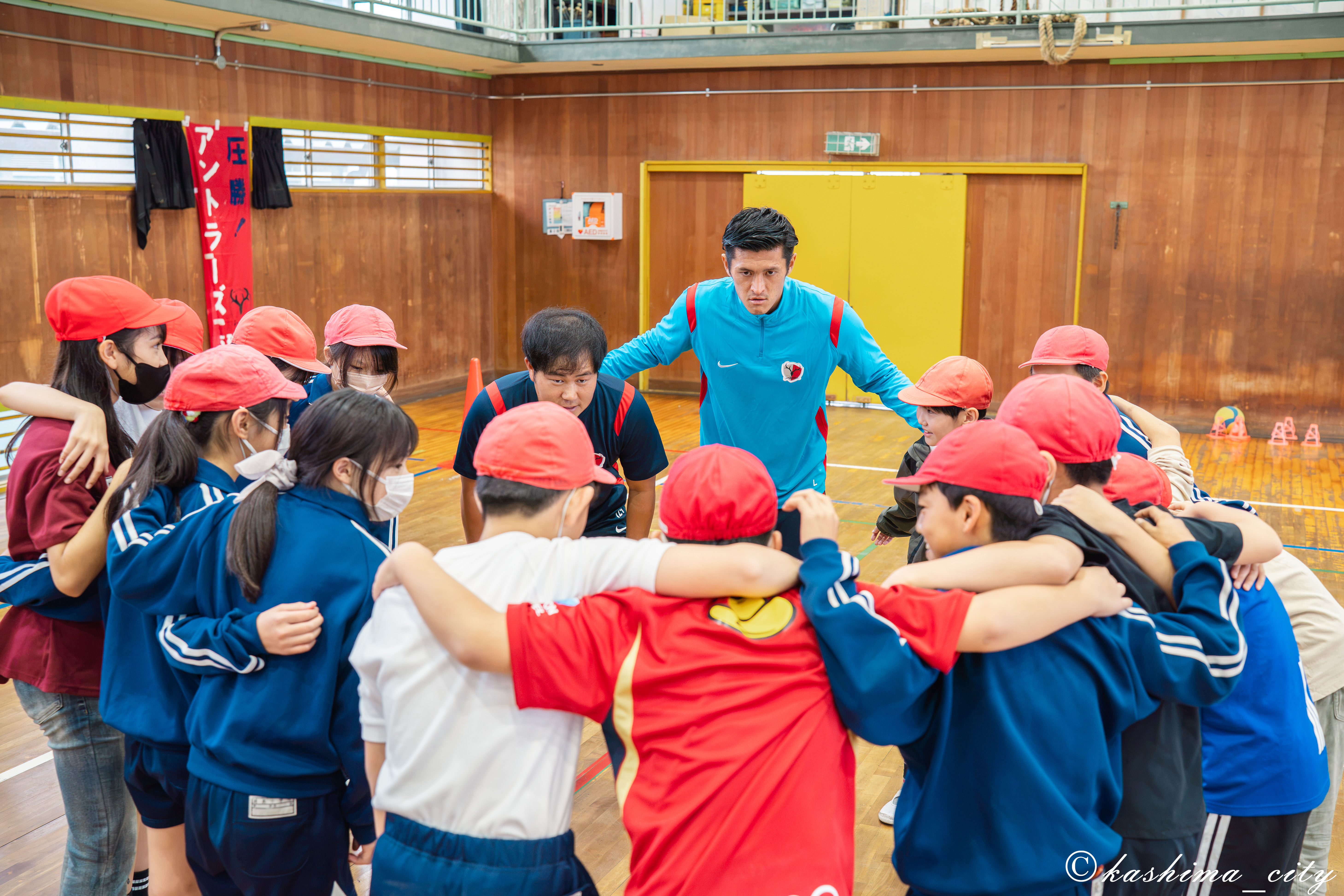 児童たちと円陣を組む植田選手