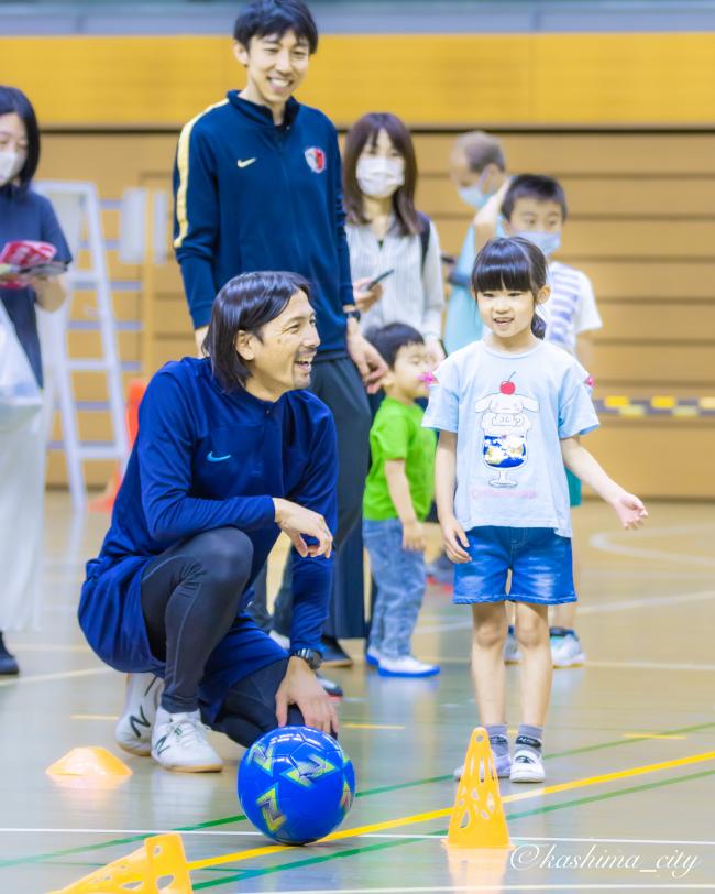鈴木隆行さんとフットゴルフをする子ども
